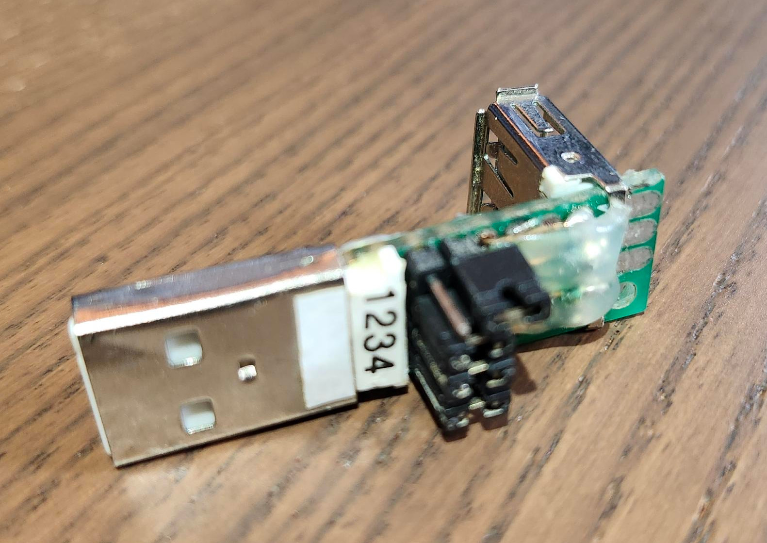 prosumer grade Homemade USB-A female to USB-A male right-angle adapter with four removable jumpers. The jumper for the 5V line is not installed.